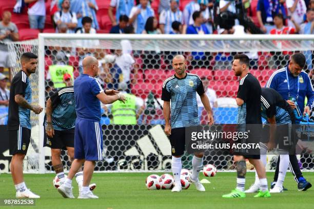 Argentina's forward Lionel Messi and Argentina's midfielder Javier Mascherano listen to Argentina's coach Jorge Sampaoli as they warm up before the...