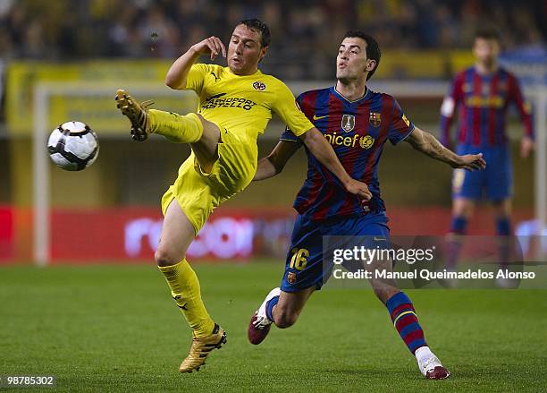 Santi Cazorla of Villarreal CF competes for the ball with Sergio Busquets of FC Barcelona with during the La Liga match between Villarreal CF and FC...