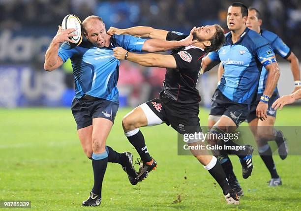 Gary Botha of the Blues is tackled by Rory Kockott of the Sharks during the Super 14 Round 12 match between the Vodacom Blue Bulls and the Sharks at...