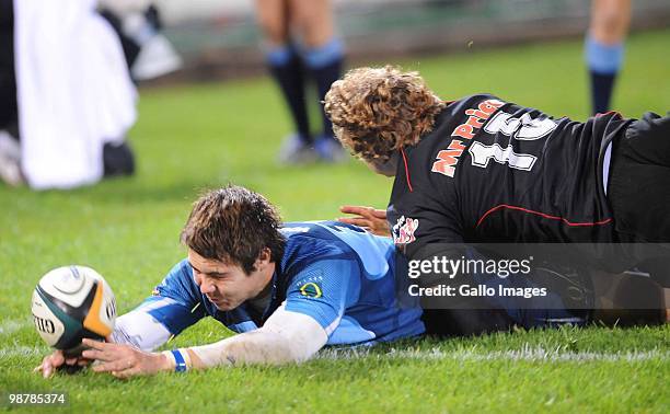 Gerhard van den Heever of the Bulls scores a try despite the attentions of Patrick Lambie of the Sharks during the Super 14 Round 12 match between...