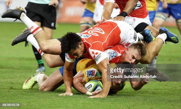 Hayden Parker and Ryoto Nakamura of Sunwolves tackle Jesse Kriel of Bulls during the Super Rugby match between Sunwolves and Bulls at the Singapore...