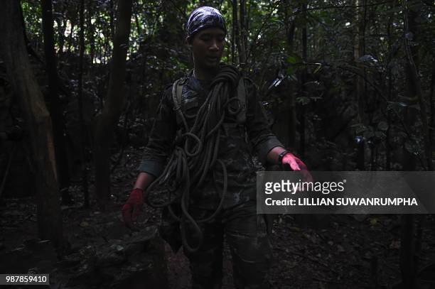 Thai Airforce soldier carries climbing rope towards a possible overground opening to Tham Luang cave, at the Khun Nam Nang Non Forest Park in Chiang...