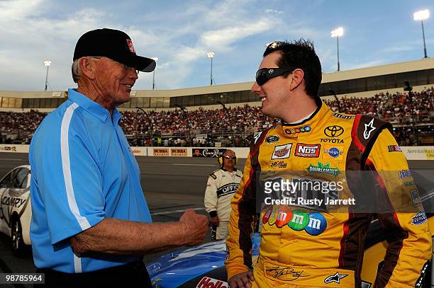 Kyle Busch, driver of the M&M's Toyota, talks with team owner Joe Gibbs prior to the start of the NASCAR Sprint Cup Series Crown Royal Presents the...