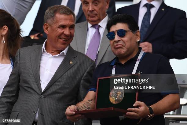 Argentinian football legend Diego Maradona poses with an award before the Russia 2018 World Cup round of 16 football match between France and...