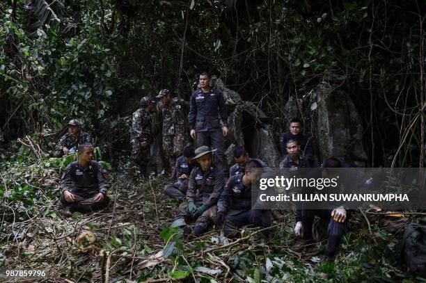 Thai Airforce soldiers wait for orders in the forest near a possible overground opening to the Tham Luang cave, at the Khun Nam Nang Non Forest Park...