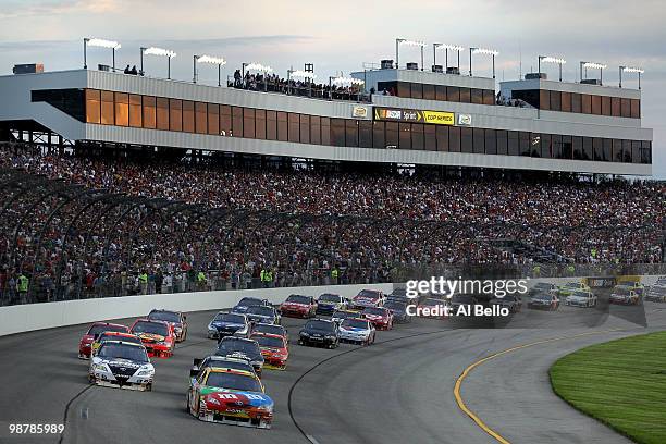 Kyle Busch, driver of the M&M's Toyota and David Reutimann , driver of the Aaron's Dream Machine Toyota, lead the field at the start of the NASCAR...