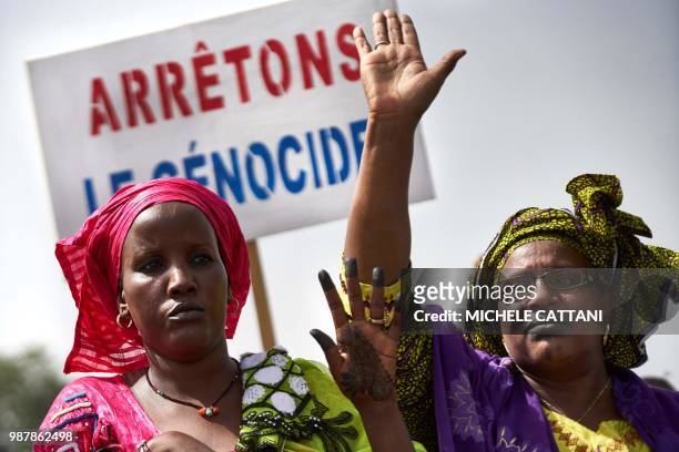 Malian women carry a banner 'Stop Genocide' as they take part in a march on June 30, 2018 in Bamako organised by the Mouvement Peul, an organisation...