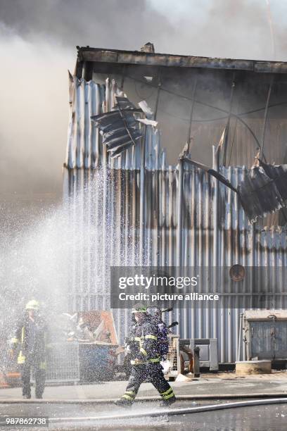 June 2018, Germany, Boenen: Emergency personnel of the fire department extinguish a fire at a recycling plant. A large-scale fire led to a...