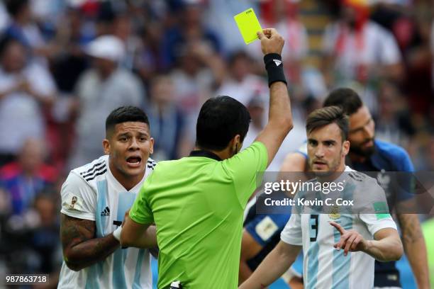 Nicolas Tagliafico of Argentina is shown a yellow card by referee Alireza Faghani during the 2018 FIFA World Cup Russia Round of 16 match between...