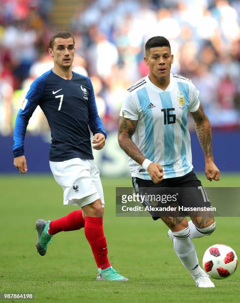 Marcos Rojo of Argentina runs with the ball under pressure from Antoine Griezmann of France during the 2018 FIFA World Cup Russia Round of 16 match...