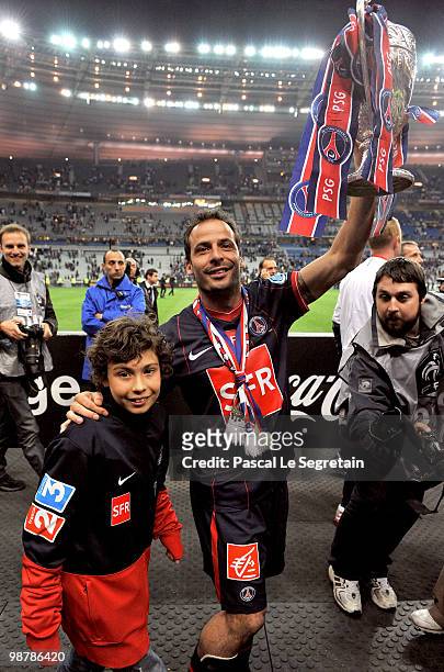 Paris Saint-Germain's French Striker Ludovic Giuly with his son holds the trophy to celebrate the winning of the French Cup final between Paris Saint...