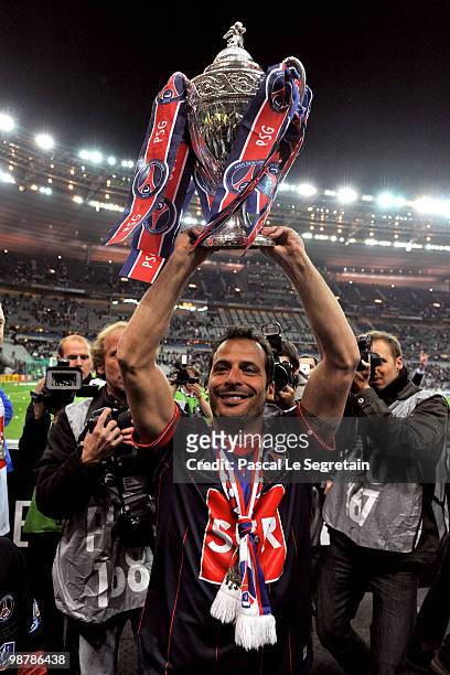 Paris Saint-Germain's French Striker Ludovic Giuly holds the trophy to celebrate the winning of the French Cup final between Paris Saint Germain...