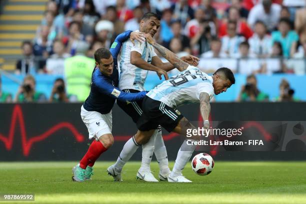 Antoine Griezmann of France battles for the ball with Gabriel Mercado and Marcos Rojo of Argentina during the 2018 FIFA World Cup Russia Round of 16...