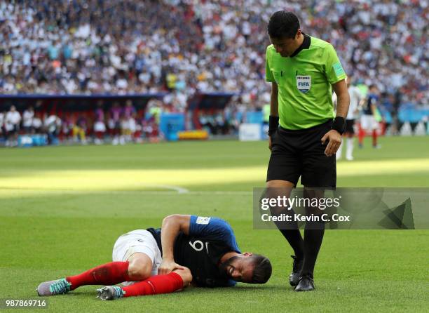 Referee Alireza Faghani checks on Olivier Giroud of France who goes down injured during the 2018 FIFA World Cup Russia Round of 16 match between...