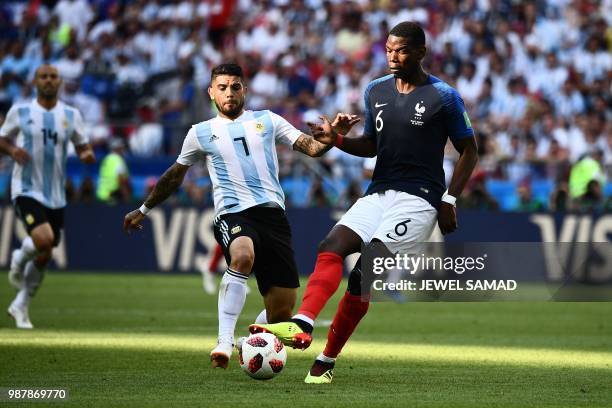 France's midfielder Paul Pogba runs with the ball as he is marked by Argentina's midfielder Ever Banega during the Russia 2018 World Cup round of 16...