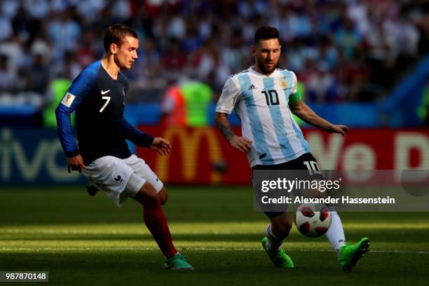 Lionel Messi of Argentina is challenged by Antoine Griezmann of France during the 2018 FIFA World Cup Russia Round of 16 match between France and...