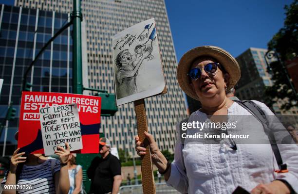 Woman holds a poster as she attends the nationwide "Families Belong Together" march on June 30, 2018 in New York City. As thousands of migrant...