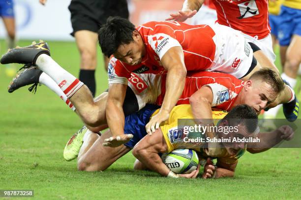 Hayden Parker and Ryoto Nakamura of Sunwolves tackle Jesse Kriel of Bulls during the Super Rugby match between Sunwolves and Bulls at the Singapore...