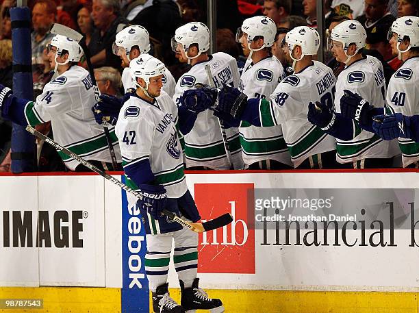 Kyle Wellwood of the Vancouver Canucks is congratulated by teammates after scoring a 2nd period goal against the Chicago Blackhawks in Game One of...