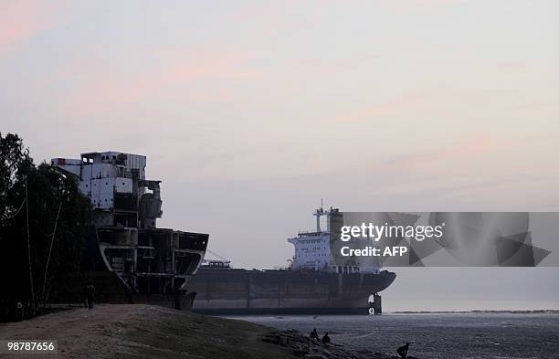 Bangladesh-environment-shipping, FEATURE by Shafiq Alam Bangladeshis sit by the sea at a shipbreaking yard in Sitakundu some 30 kms from the port...