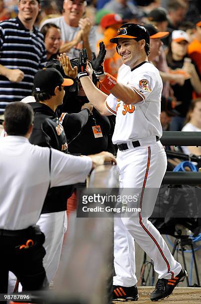 Luke Scott of the Baltimore Orioles celebrates with teammates after hitting a home run in the seventh inning against the Boston Red Sox at Camden...
