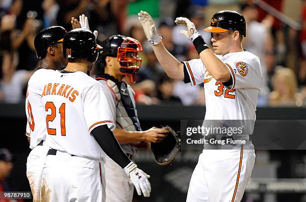 Matt Wieters of the Baltimore Orioles celebrates with Nick Markakis and Adam Jones after hitting a home run in the fifth inning against the Boston...