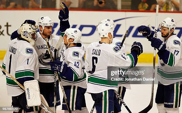 Roberto Luongo of the Vancouver Canucks is congratulated by Shane O'Brien and Kyle Wellwood as teammates Sami Salo and Ryan Kesler celebrate a win...