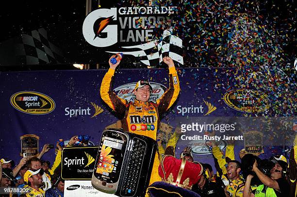 Kyle Busch, driver of the M&M's Toyota, celebrates in victory lane after he won the NASCAR Sprint Cup Series Crown Royal Presents the Heath Calhoun...