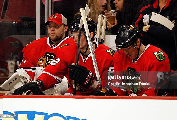 Starting goalie Antti Niemi of the Chicago Blackhawks sits on the bench in the 3rd period with teammates Tomas Kopecky and Marian Hossa against the...