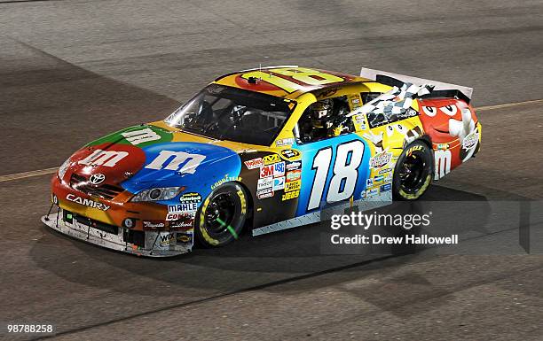 Kyle Busch, driver of the M&M's Toyota, celebrates with the checkered flag after he won the NASCAR Sprint Cup Series Crown Royal Presents the Heath...