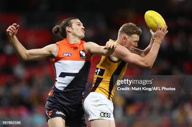 James Sicily of the Hawks takes a mark under pressure from Phil Davis of the Giants during the round 15 AFL match between the Greater Western Sydney...