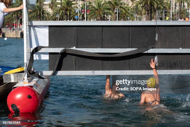 Two swimmers are seen at the arrival performing the electronic control of arrival. The 91A across the port of Barcelona involves different sports...