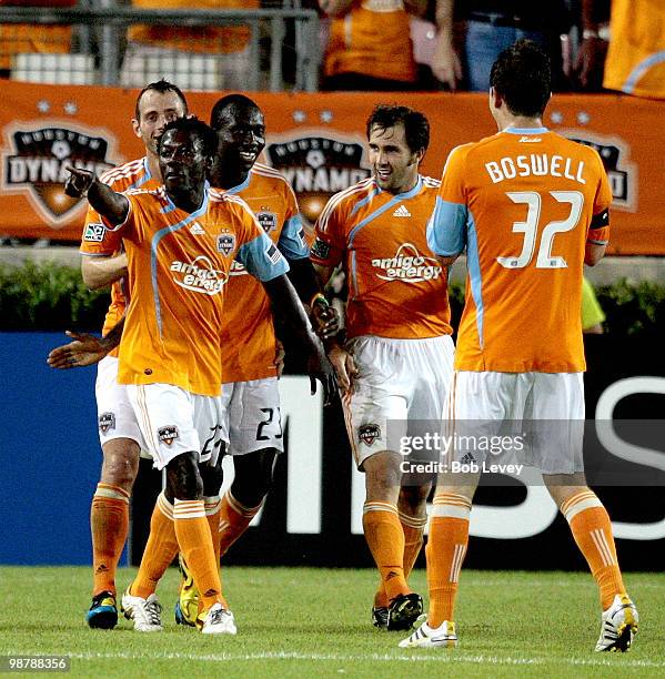 Samuel Appiah points to the Houston Dynamo bench as he is congratulated by Dominic Oduro, Brian Mullan, center, and Bobby Boswell after scoring...