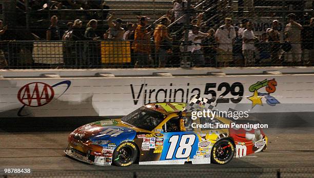 Kyle Busch, driver of the M&M's Toyota, celebrates with the checkered flag after he won the NASCAR Sprint Cup Series Crown Royal Presents the Heath...