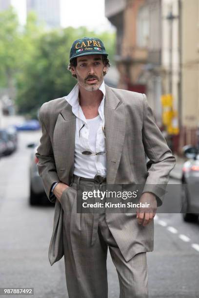 Model Richard Biedul wears an Alex Mullins suit and Palace skateboards cap during London Fashion Week Men's on June 10, 2018 in London, England.