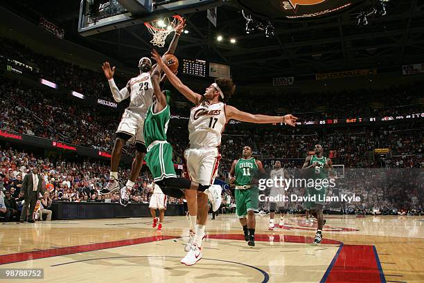 Rajon Rondo of the Boston Celtics goes up for the shot against LeBron James and Anderson Varejao of the Cleveland Cavaliers in Game One of the...