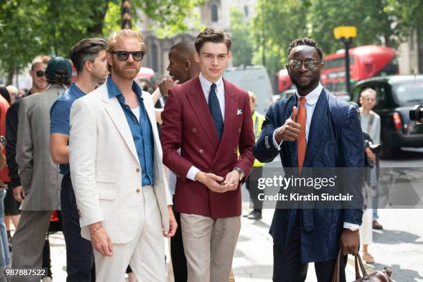 Photographer Alistair Guy wears an English Cut suit, Celine sunglasses and Tommy Hilfiger shirt with Digital Influencer Mathias le Feuvre wearing an...