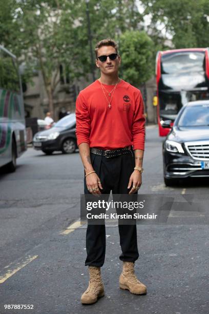 Made in Chelsea star Oliver Proudlock wears a Christopher Raeburn for Timberland top, Tom Davis sunglasses and vintage boots during London Fashion...