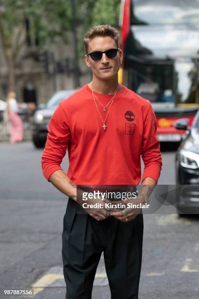 Made in Chelsea star Oliver Proudlock wears a Christopher Raeburn for Timberland top, Tom Davis sunglasses during London Fashion Week Men's on June...
