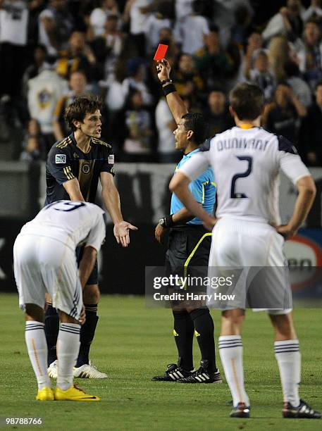 Stefani Miglioranzi of the Philadelphia Union receives a red card from referee Yader Reyes in front of Juninho and Todd Dunnivant of the Los Angeles...