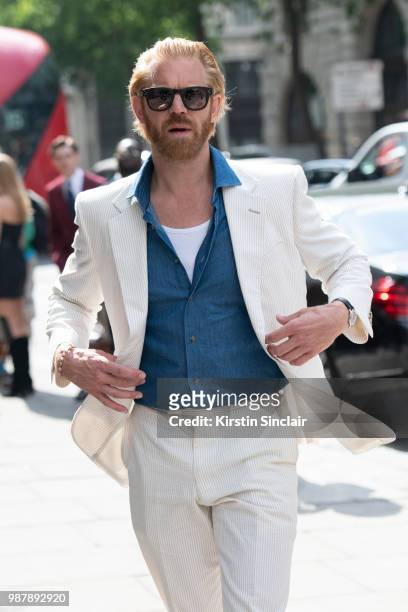 Photographer Alistair Guy wears an English Cut suit, Celine sunglasses and Tommy Hilfiger shirt London Fashion Week Men's on June 10, 2018 in London,...