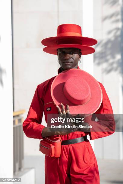 Creative Director and stylist Abdel Keita Tavares wears a Dickies boiler suit and his own design hats during London Fashion Week Men's on June 10,...