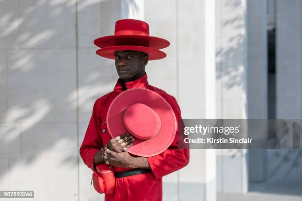 Creative Director and stylist Abdel Keita Tavares wears a Dickies boiler suit and his own design hats during London Fashion Week Men's on June 10,...