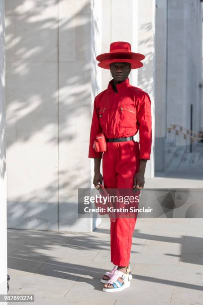 Creative Director and stylist Abdel Keita Tavares wears Doc Martens sandals, Dickies boiler suit and his own design hats during London Fashion Week...