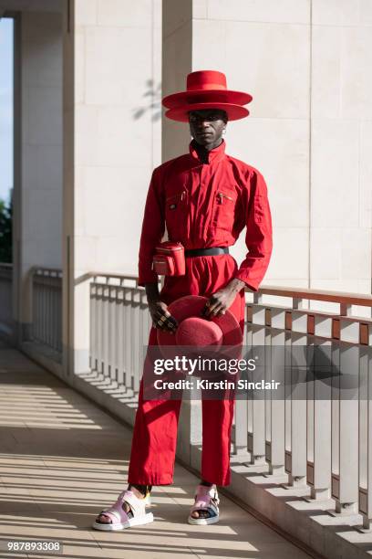 Creative Director and stylist Abdel Keita Tavares wears Doc Martens sandals, Dickies boiler suit and his own design hats during London Fashion Week...