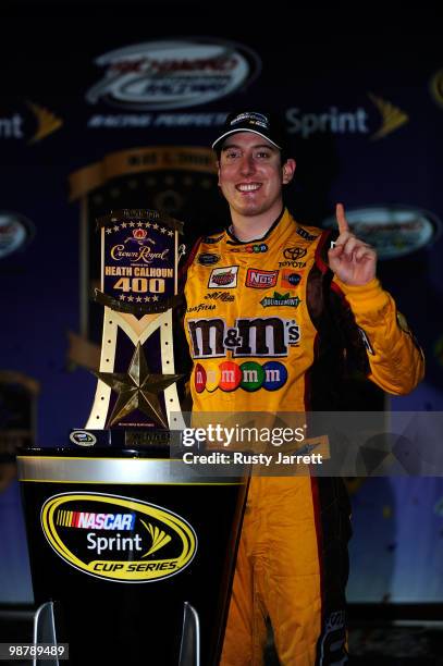 Kyle Busch, driver of the M&M's Toyota, celebrates with the trophy in victory lane after winning the NASCAR Sprint Cup Series Crown Royal Presents...