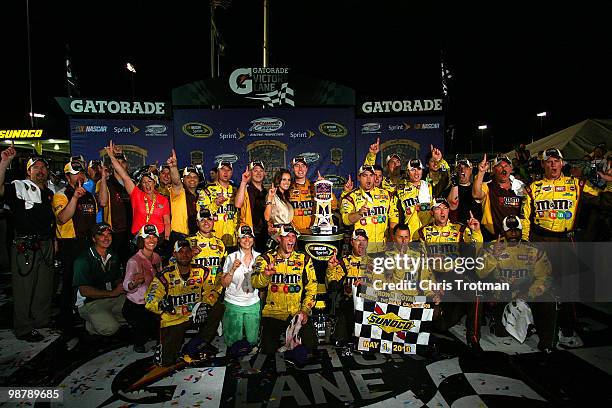 Kyle Busch, driver of the M&M's Toyota, celebrates with his crew in victory lane after winning the NASCAR Sprint Cup Series Crown Royal Presents the...