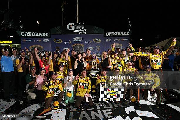 Kyle Busch, driver of the M&M's Toyota, celebrates with his crew in victory lane after winning the NASCAR Sprint Cup Series Crown Royal Presents the...