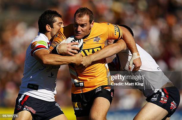 Gareth Ellis of the Tigers takes on the defence during the round eight NRL match between the Wests Tigers and the Sydney Roosters at Campbelltown...