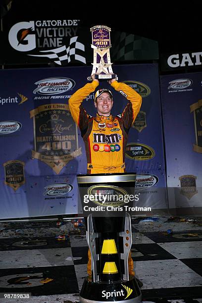 Kyle Busch, driver of the M&M's Toyota, celebrates with the trophy in victory lane after winning the NASCAR Sprint Cup Series Crown Royal Presents...